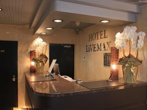 羽村市HOTEL LiVEMAX BUDGET Tokyo Hamura Ekimae的酒店大堂设有前台,走廊上设有酒店走廊