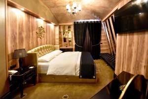 波格拉德茨Hotel Hymeti's Palace的一间卧室配有一张床和一个吊灯