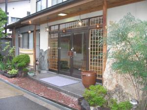 山之内町汤田中和平旅馆的一座带大玻璃门的建筑的入口