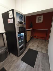 格拉索比奥Airport Boulevard Guesthouse的客房设有大冰箱和桌子。