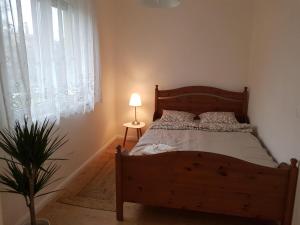 艾斯特根Kislakás Esztergomban的一间卧室配有一张木床、灯和植物