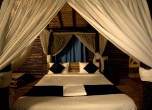 海得拉巴Farm Stay Resort - Shamirpet, Hyderabad的卧室配有带白色窗帘的天蓬床