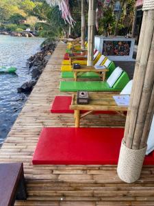 皮皮岛Phi Phi Green House & Sunsky Hostel的码头上一排带彩色垫子的桌子