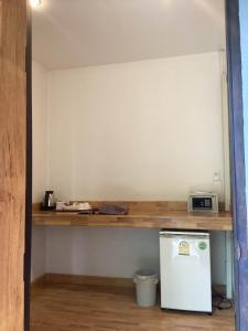 班柯木KOHMOOK THE SUN GREAT RESORT的厨房配有柜台和小冰箱