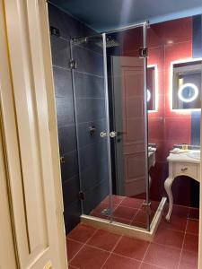 波格拉德茨Hotel Hymeti's Palace的浴室里设有玻璃门淋浴