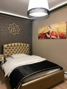 波格拉德茨Hotel Hymeti's Palace的卧室配有一张床,墙上挂有绘画作品