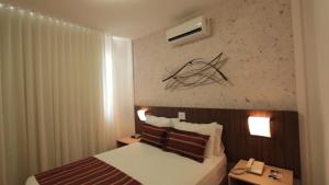 贝洛奥里藏特Pampulha Lieu Hotel的酒店客房,设有床铺和2个床头柜