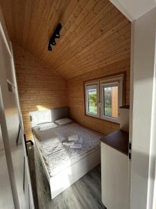 弗瓦迪斯瓦沃沃RYBY W SIECI的一间小卧室,配有一张位于木制房间内的床