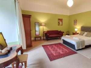 Mealsgate怀特豪尔乡村别墅的一间卧室配有一张床和一张红色的沙发