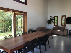 JaguariaívaCasa de campo com piscina的客厅里设有一张大木桌子和椅子