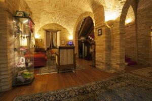 MontecosaroLa Luma Hotel的客厅设有石墙和桌子