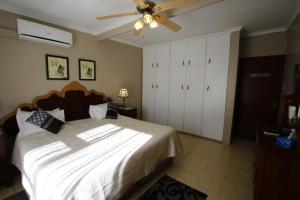 伊丽莎白港蓝水宾馆的一间卧室配有一张床和吊扇