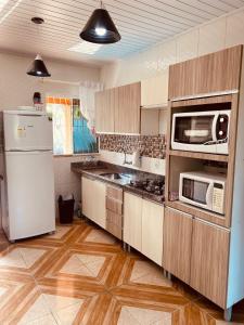 拉古纳Rest house的厨房配有白色冰箱和微波炉