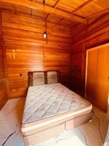 拉古纳Rest house的木墙客房内的小床