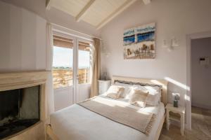 圣温琴佐Castel del Mare的一间白色卧室,配有一张床和一个壁炉