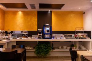 罗马迪罗马瑞丽酒店的柜台上设有咖啡机的餐厅