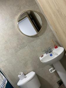 普罗维登西亚Providence Paradise的浴室设有镜子、卫生间和水槽