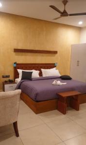 阿勒皮Casa Orchid的一间卧室配有一张大床和紫色毯子