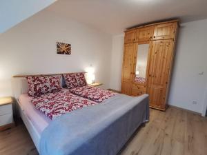 卡珀尔恩Ostseeblick im Andersenhof的一间卧室配有一张大床和一个木制橱柜