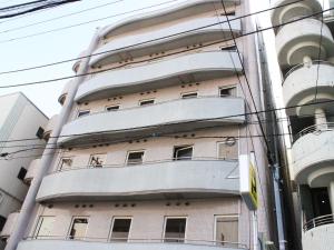 东京HOTEL LiVEMAX BUDGET Tokyo Kiba的公寓大楼的一侧设有阳台。