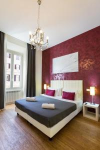 罗马亚历山大宾馆的一间卧室设有一张红色墙壁的大床