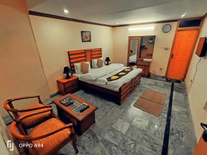 伊斯兰堡Lexus Lodge的卧室配有1张床、1张桌子和1把椅子