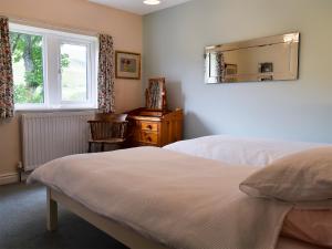 凯特尔韦尔Fell View的一间卧室设有两张床、镜子和窗户