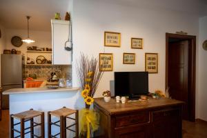 诺托Country House il Gelso e l’Ulivo的厨房配有带电视和2张凳子的柜台