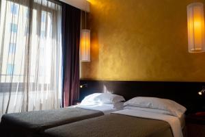 罗马迪罗马瑞丽酒店的一间卧室配有带两个枕头的床和窗户