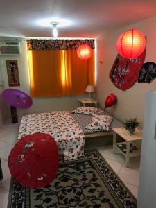 布希奥斯Flats vila bela Búzios的卧室配有两把红色遮阳伞。