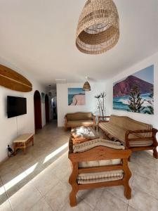 拉奥利瓦Pura Vida Surf Camp & School的客厅配有木制家具和吊灯。