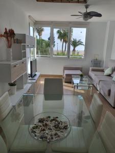 滨海罗克塔斯Primera línea playa的客厅配有玻璃桌和沙发