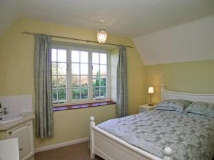 Hovingham豪斯农场乡村别墅的一间卧室配有床、水槽和窗户
