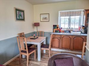 Hovingham豪斯农场乡村别墅的厨房配有桌椅和水槽。