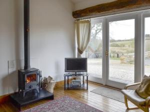 北威灵厄姆布赖德尔斯乡村别墅 的客厅设有壁炉和电视。