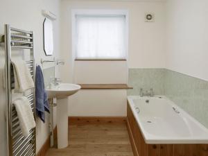 北威灵厄姆布赖德尔斯乡村别墅 的一间带水槽和浴缸的浴室以及窗户。