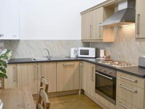 北威灵厄姆布赖德尔斯乡村别墅 的厨房配有木制橱柜、微波炉和桌子