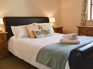 Crackington Haven教堂景度假屋的一间卧室配有一张带黑色床头板和枕头的床。