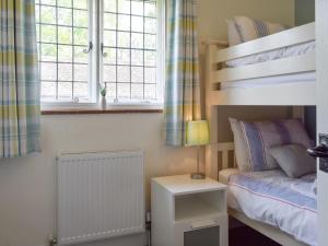 大米森登金斯希尔农场小屋酒店的一间卧室配有双层床和床头柜