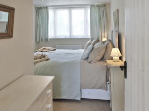 黑尔斯沃思多芙乡村别墅的卧室配有白色的床和窗户