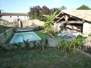 Celles-sur-BelleLe Logis de Miserè的一个带游泳池和房子的后院