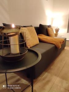 Mézières-sur-Seinelogement Mezzanine salon indépendant的一张带枕头的黑色沙发,一张桌子上的蜡烛