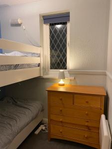 滕比Ploughmans Cottage, St Florence, Tenby的一间卧室配有一张床、一个梳妆台和一扇窗户。