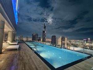 迪拜Paramount Hotel Midtown Flat with Burj Khalifa View的一座城市天际线建筑屋顶上的游泳池