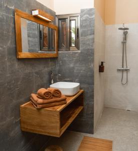 洛美Nomads的浴室配有盥洗盆、镜子和毛巾