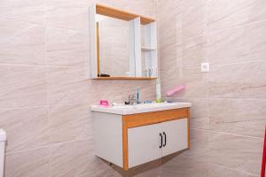 布琼布拉Cheerful 4-bedroom home with parking的一间带水槽和镜子的浴室