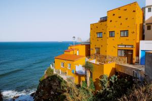 Almáciga卡萨那格公寓的海边悬崖上的黄色建筑