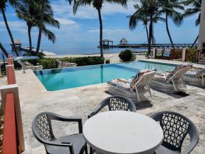 圣佩德罗Miramar Villas Resort的游泳池旁的桌椅