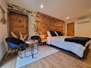 圣沙蒙La Voûte du Pilat & ces options SPA, table d'hôtes, massages的一间卧室设有一张大床和砖墙