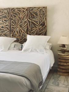 PignaCasa Legna的卧室配有白色的床和木制床头板